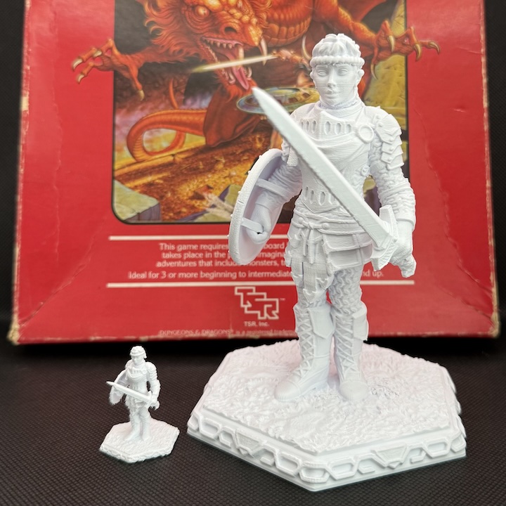A 3D printed 25mm miniature and a 400% scaled up version, in front of the 1983 D&D Basic Set