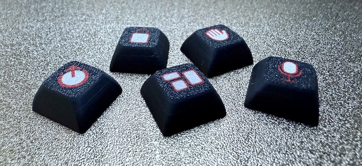 Five black keycaps with custom red and white legends